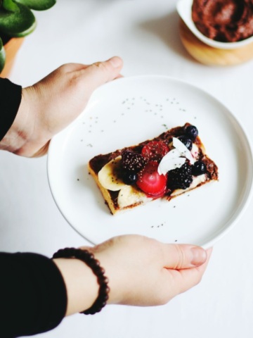 Hand holding plate of food