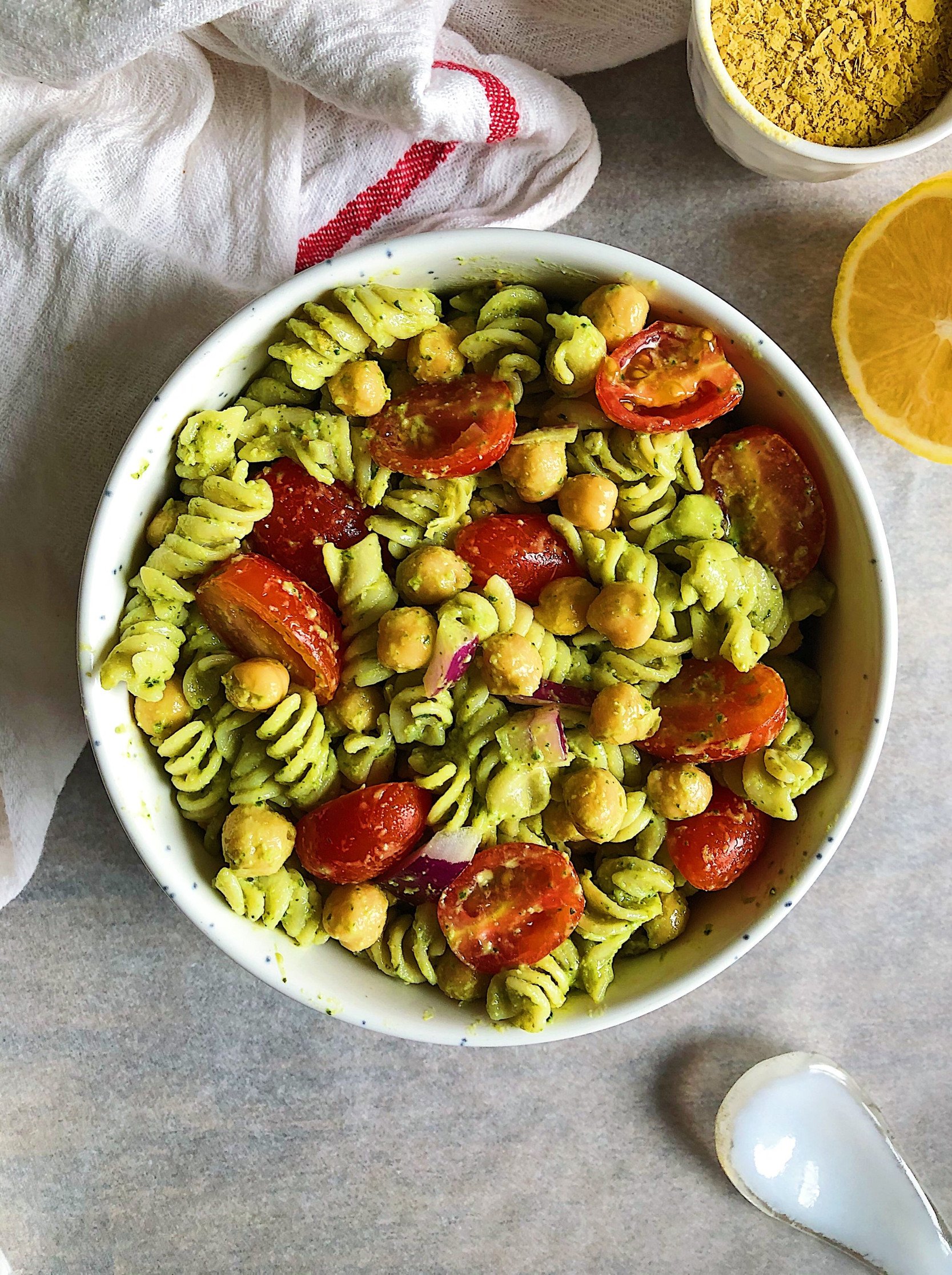 Photo of bowl of pasta with pesto on it and chickpeas and sundried tomatoes.
