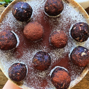 A plate of protein balls on a plate sprinkled with chocolate.