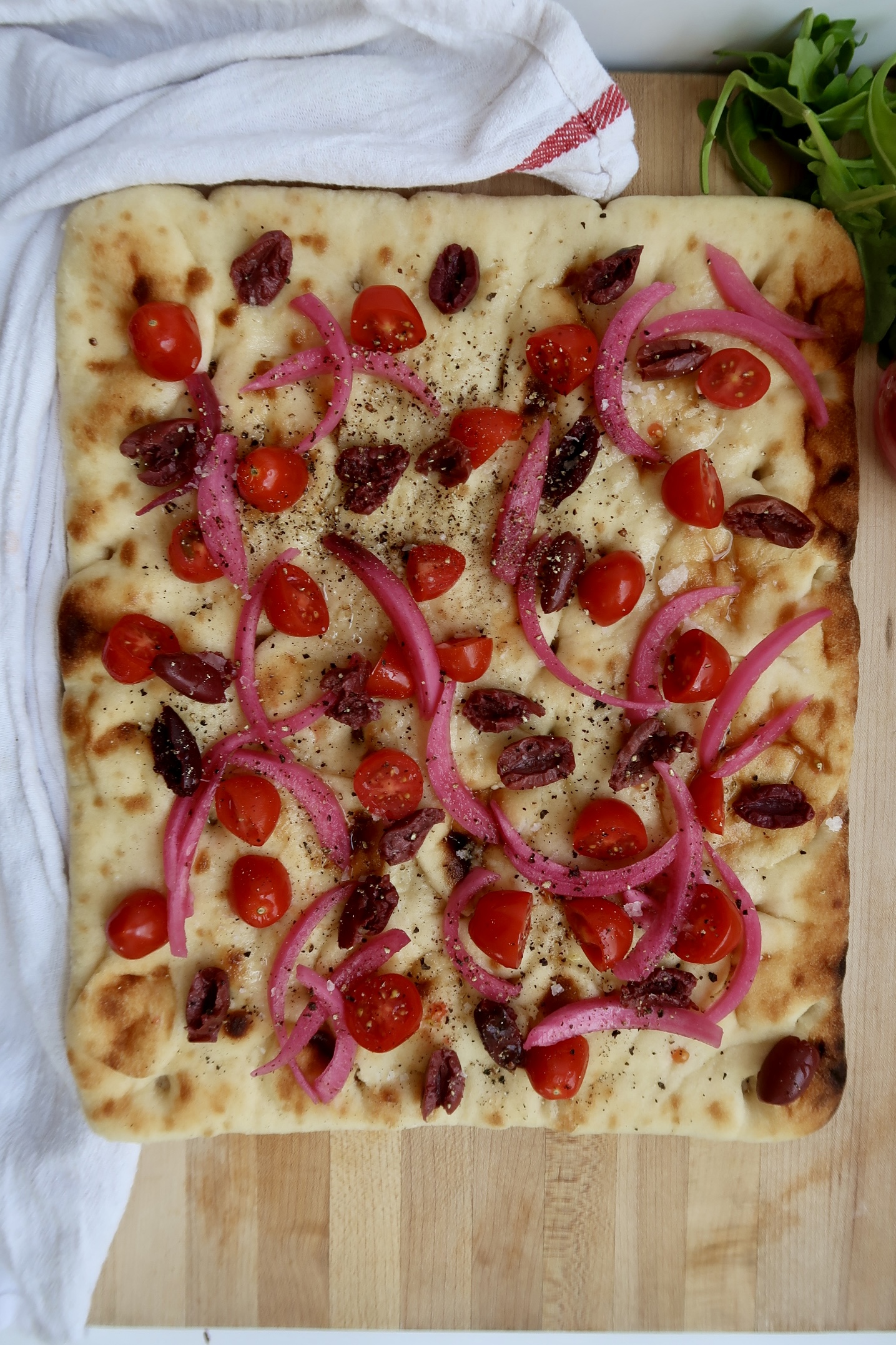 Flatbread with kalamata olives, pickled red onion and cherry tomatoes