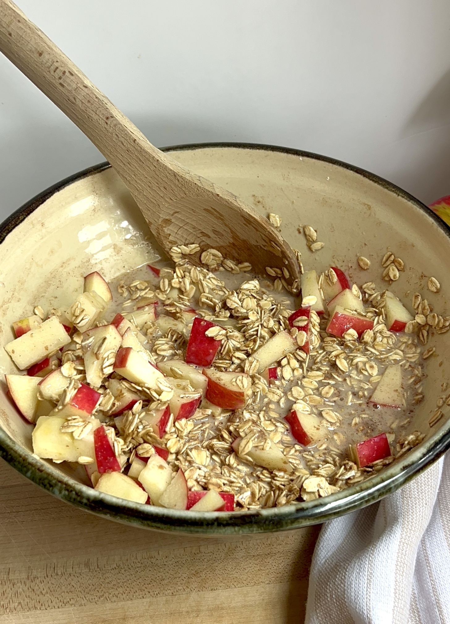 Large bowl with oats mixed with soy milk and sliced apple.