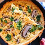 Cast iron pan with a vegan quiche inside with mushrooms and broccoli.