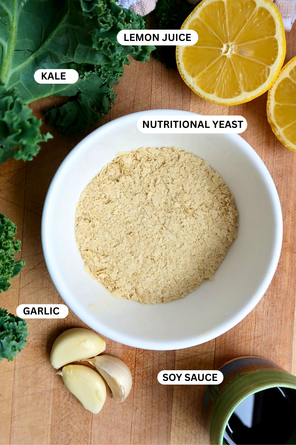 Flatlay of kale, nutritional yeast, lemon, garlic and soy sauce.