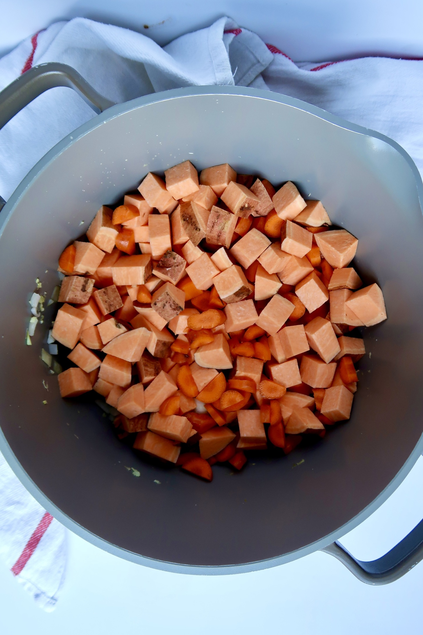 Large pot with diced sweet potato and carrot inside.