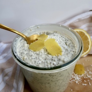 Jar with chia pudding and lemon zest on top with a spoon in it.