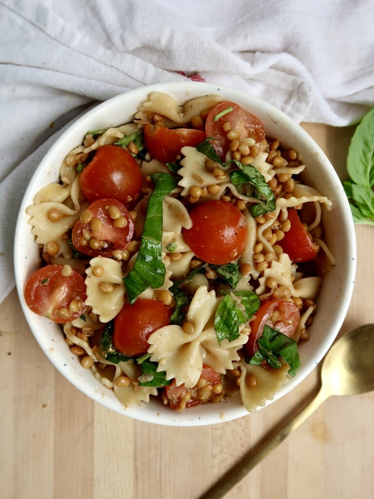 Bowl with pasta, cherry tomatoes, basil, lentils.