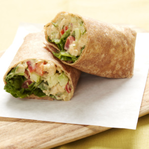 Wrap sliced in half with apple dill chickpea mash inside, bell pepper and green lettuce.
