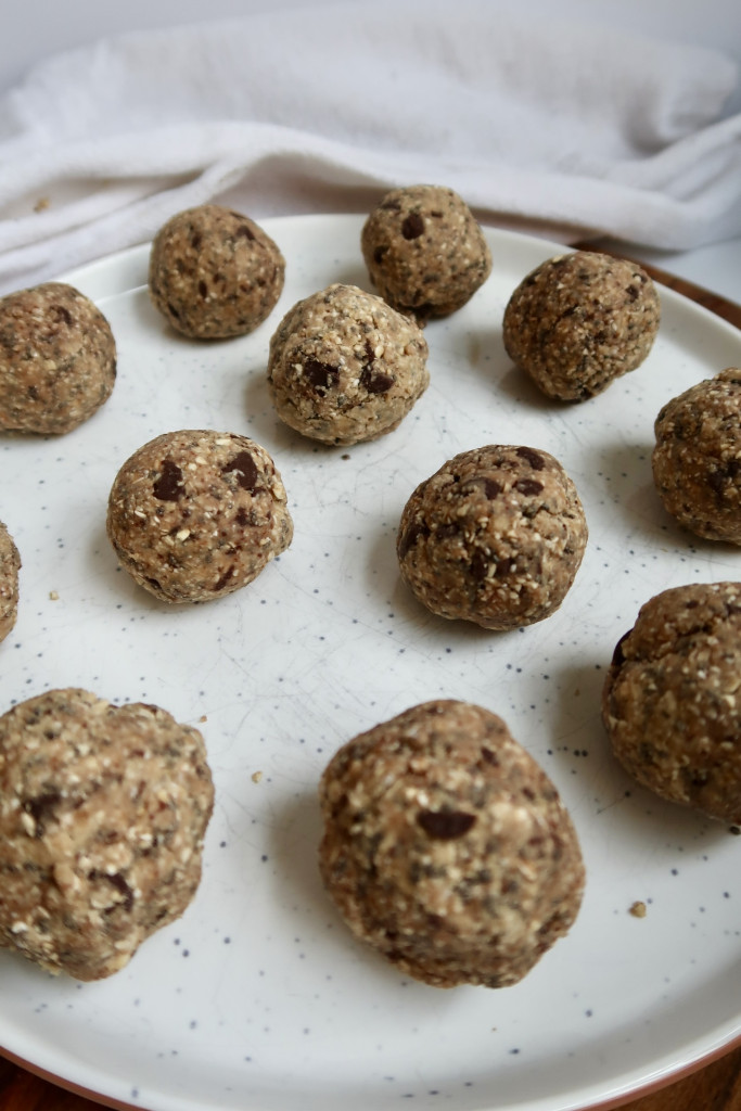 White plate with energy balls with chocolate chips in them.