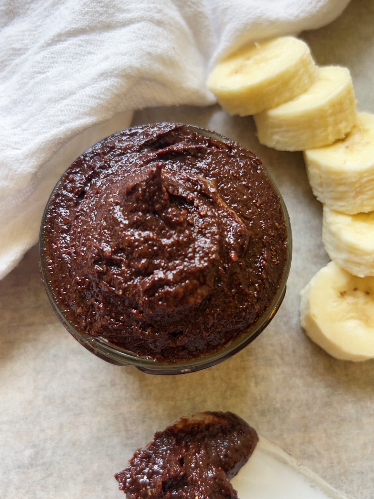 Bowl of homemade vegan nutella with a sliced banana on the side.