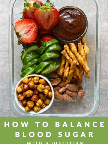 Vegan snack box lunch with strawberries, vegan nutella, pretzels, roasted chickpeas, almonds and cucumber in a glass container with the text how to balance blood sugar with a dietitian below.