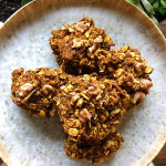 Plate with pumpkin spice muffin tops and plants in the background.