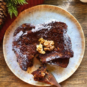 Plate with Vegan Gingerbread French toast with a fork cutting a piece from it.