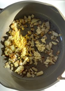 Pan with diced onion, garlic and ginger with spices.