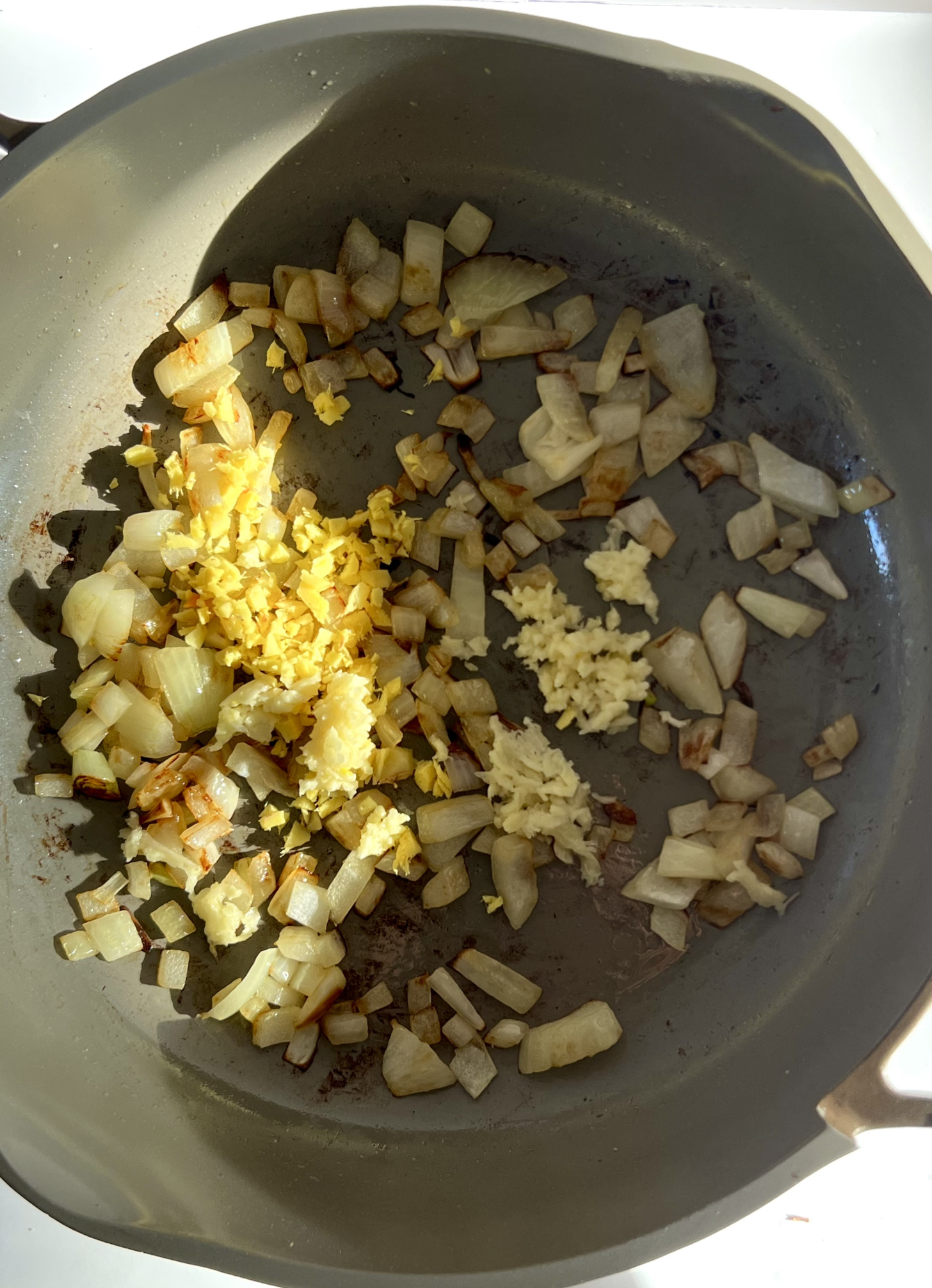 Medium pan with sauteed onion, garlic and ginger.