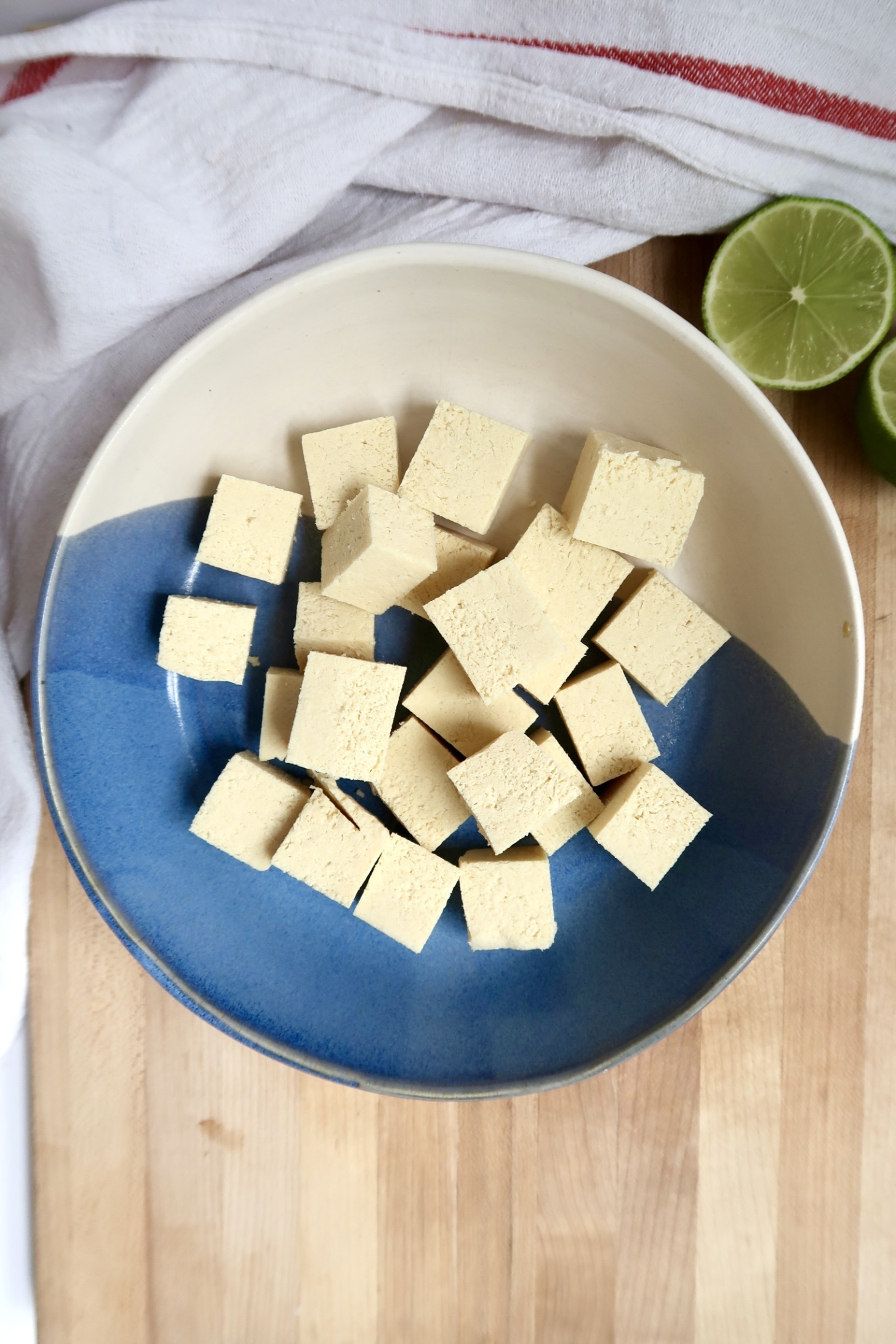 White and blue bowl with cubed tofu in it.