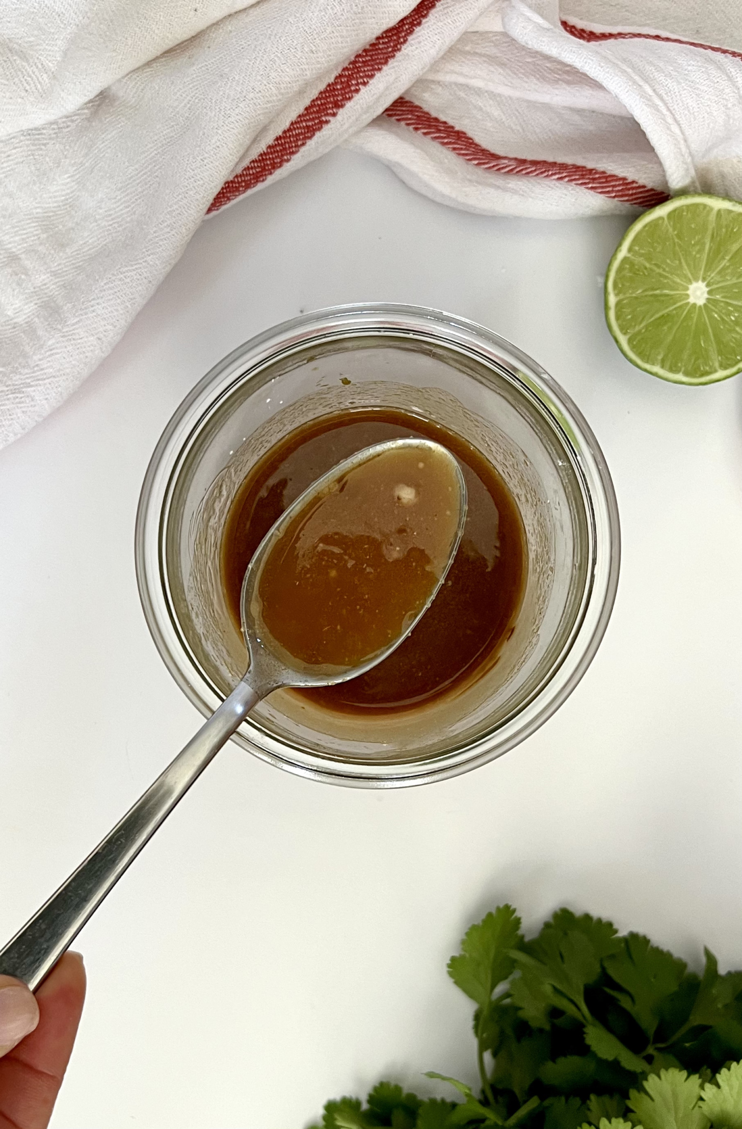 Mason jar with teriyaki sauce with a spoon in it.