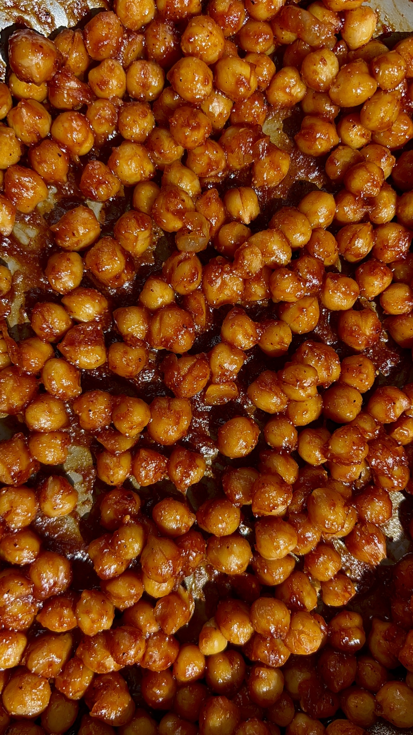 Close up shot of chickpeas covered in BBQ sauce.