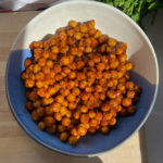 Chickpeas covered in BBQ sauce in a bowl with cilantro on the side.