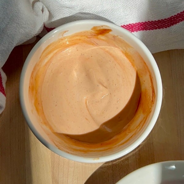 White bowl with mayo BBQ sauce inside and tofu on the side