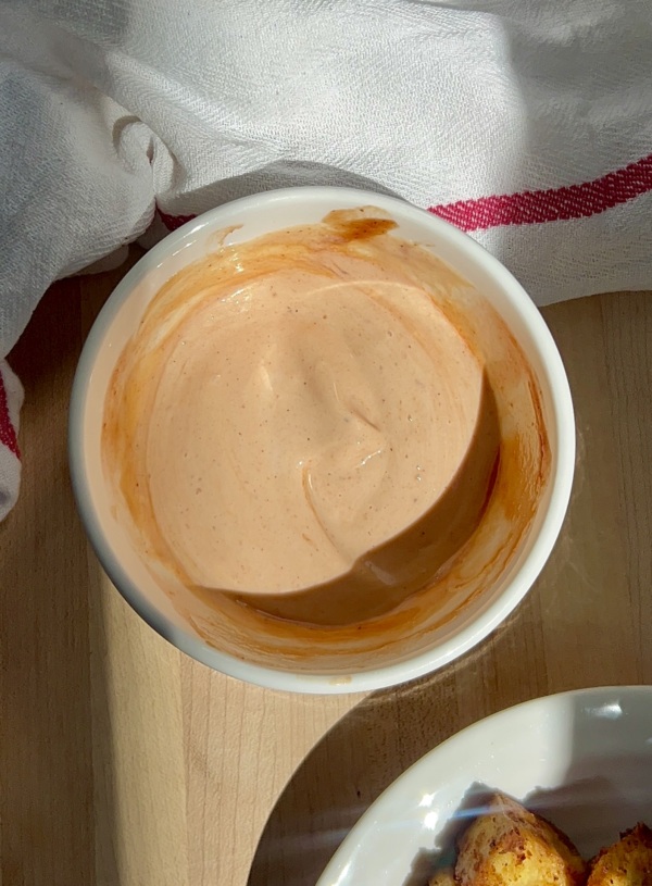 White bowl with mayo BBQ sauce inside and tofu on the side