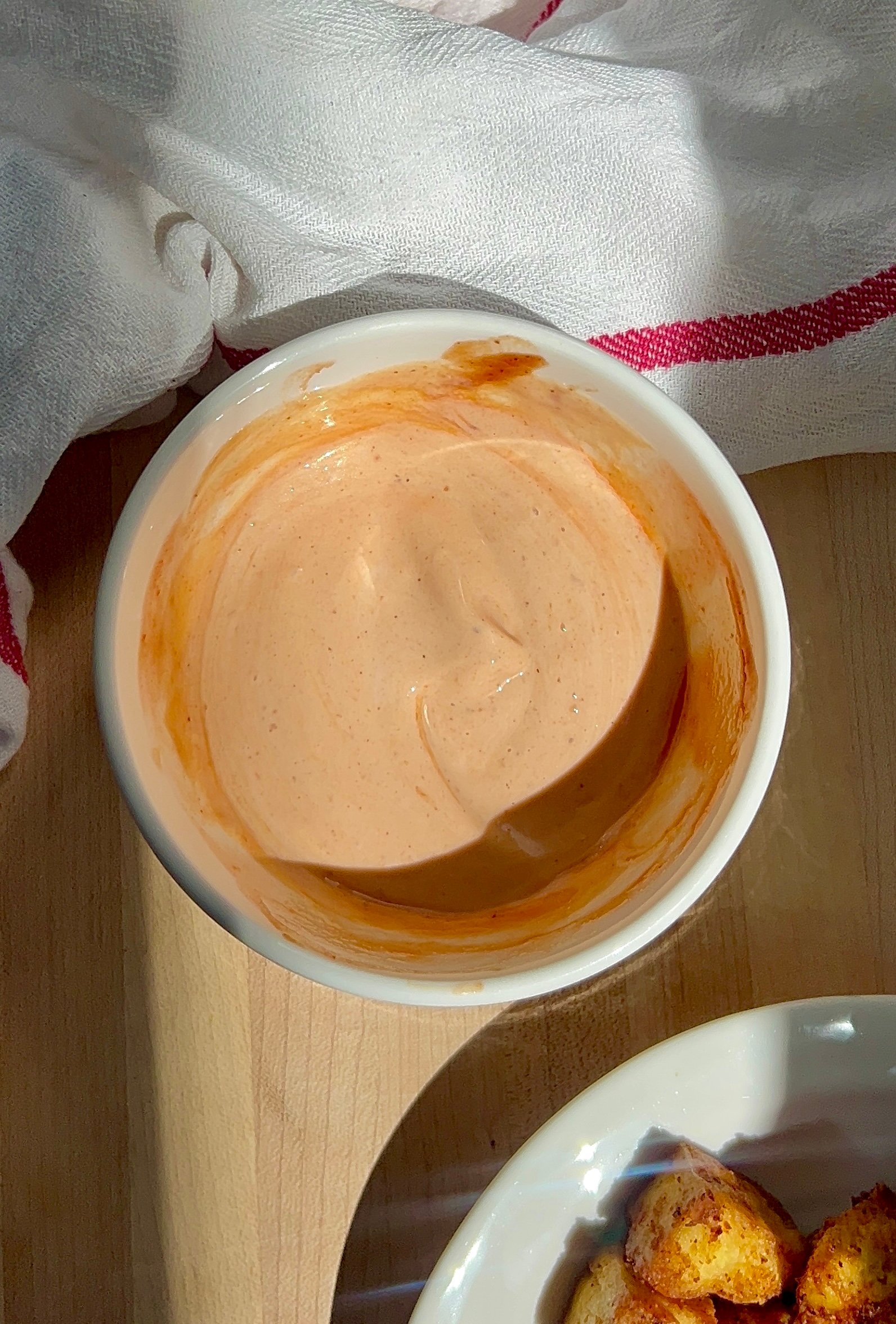 White bowl with mayo BBQ sauce inside and tofu on the side