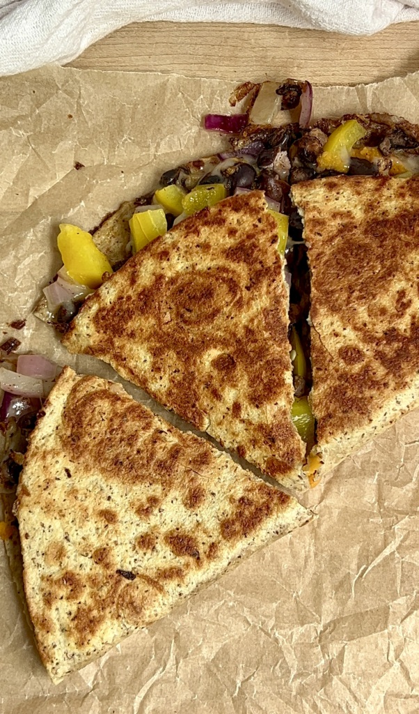 Cooked quesadilla sliced into 3 on parchment paper