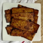 White plate with strips of tofu bacon on top.