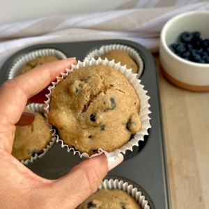 Hand holding blueberry muffin