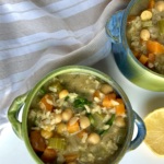 Two small blue and green soup bowls with soup inside with chickpeas, celery and rice.