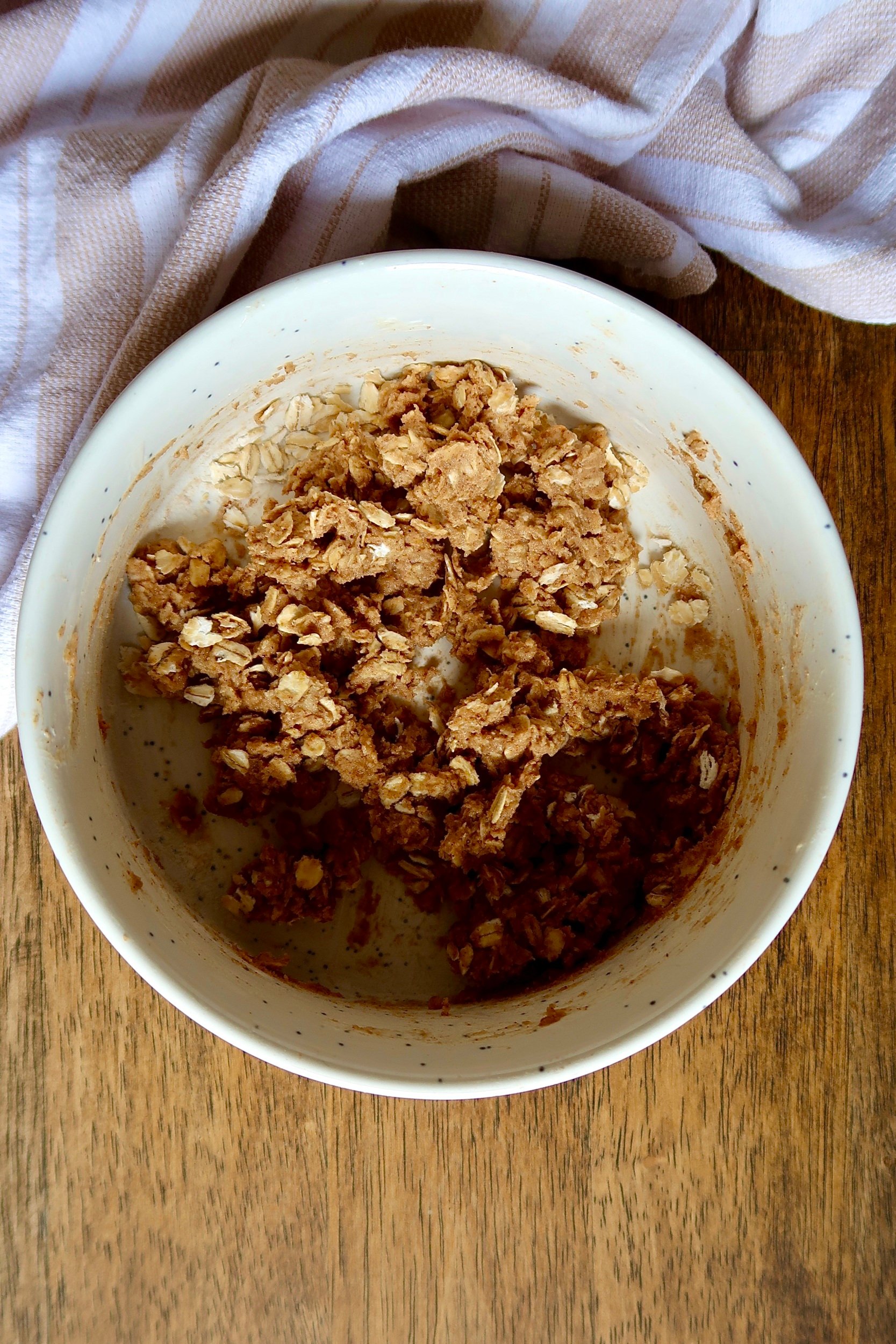 Uncooked apple crumble topping in a white bowl