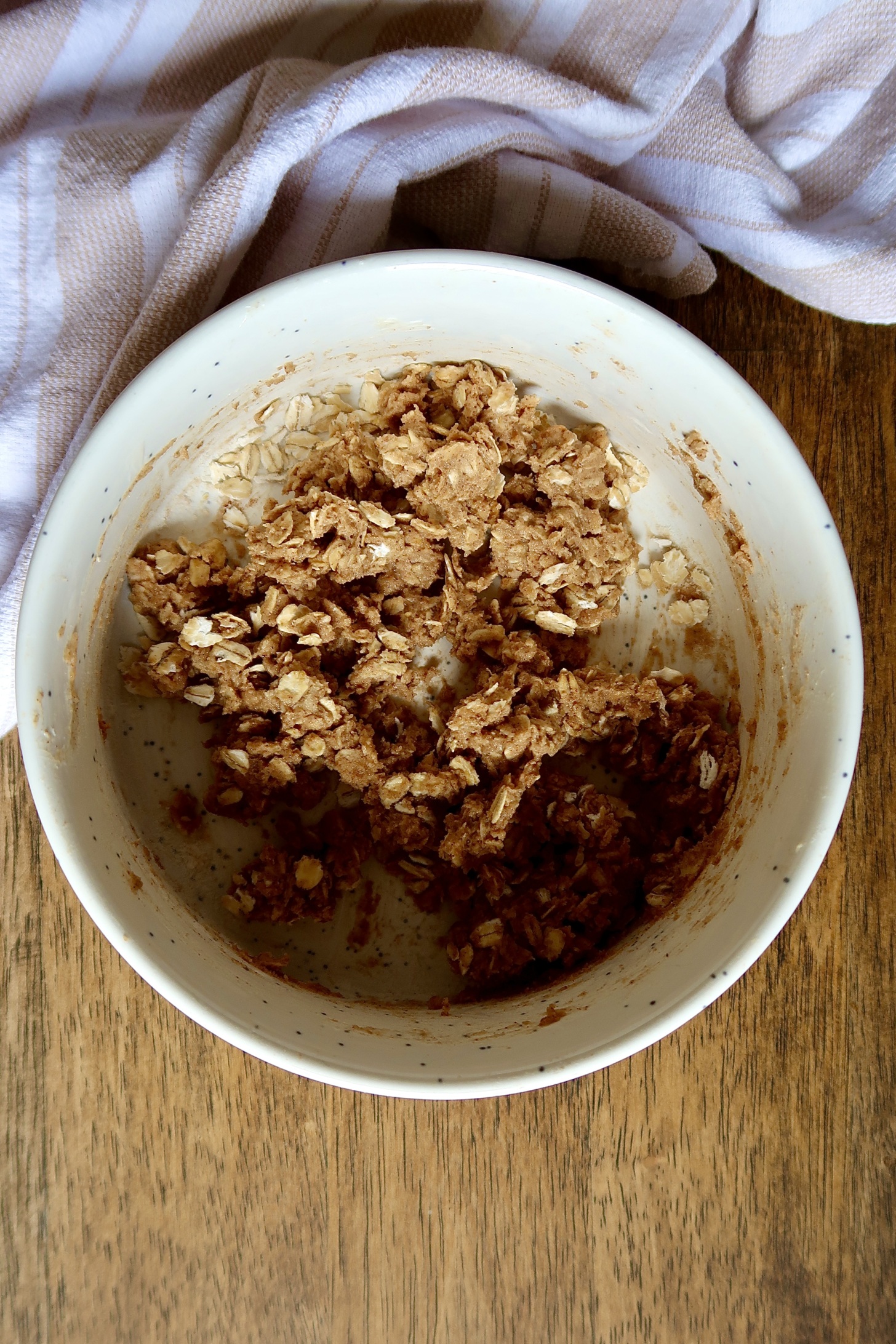 Uncooked apple crumble topping in a white bowl