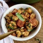 Bowl with gnocchi, sausage and sage on top.