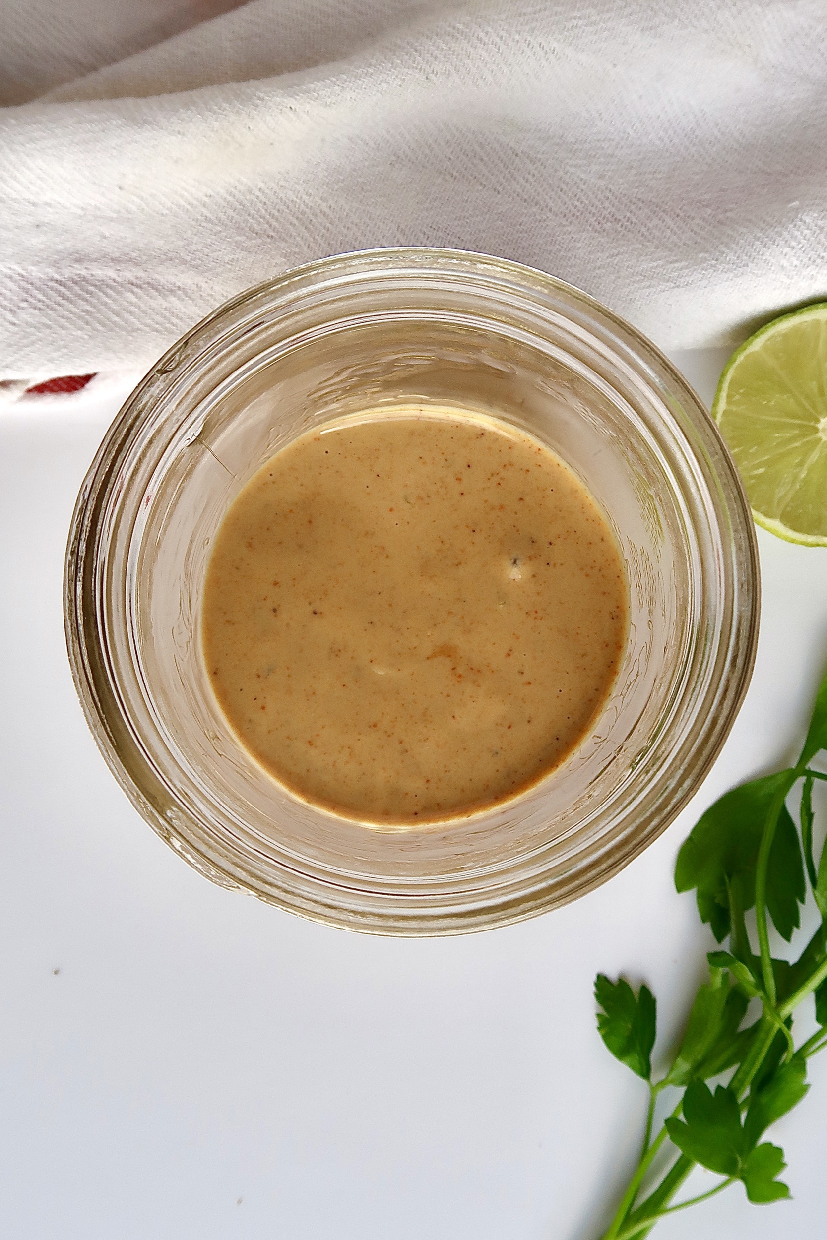 Overhead shot of jar with tahini dressing inside.