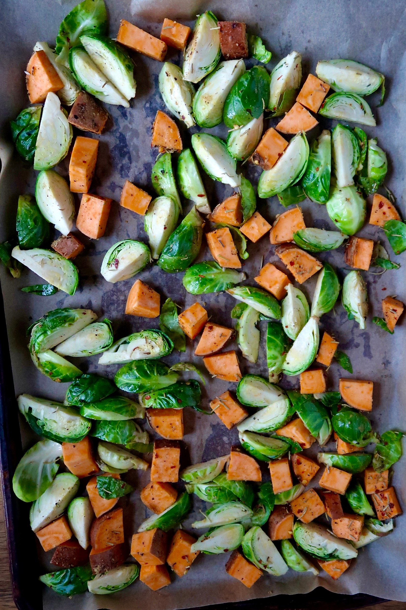 Sheet pan with diced brussel sprouts and sweet potato with oil and spices