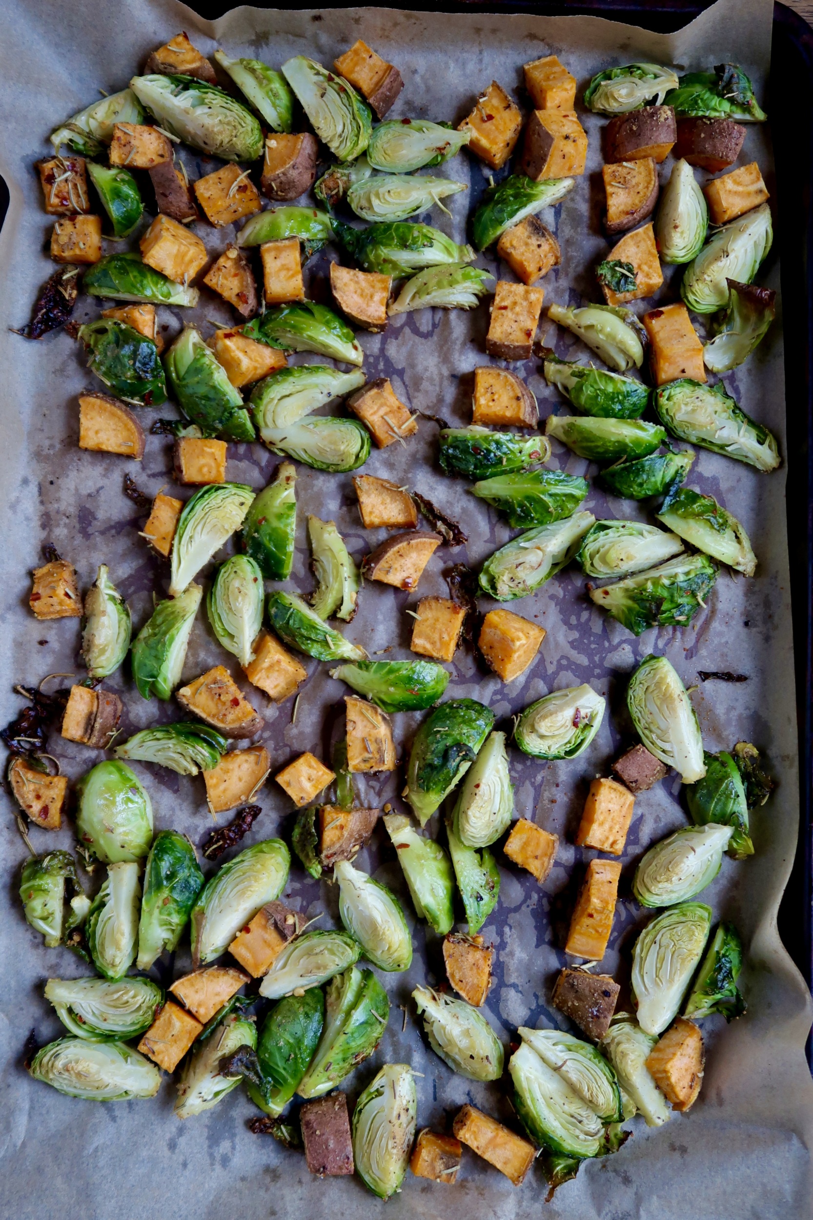 Sheet pan with diced brussel sprouts and sweet potato with oil and spices