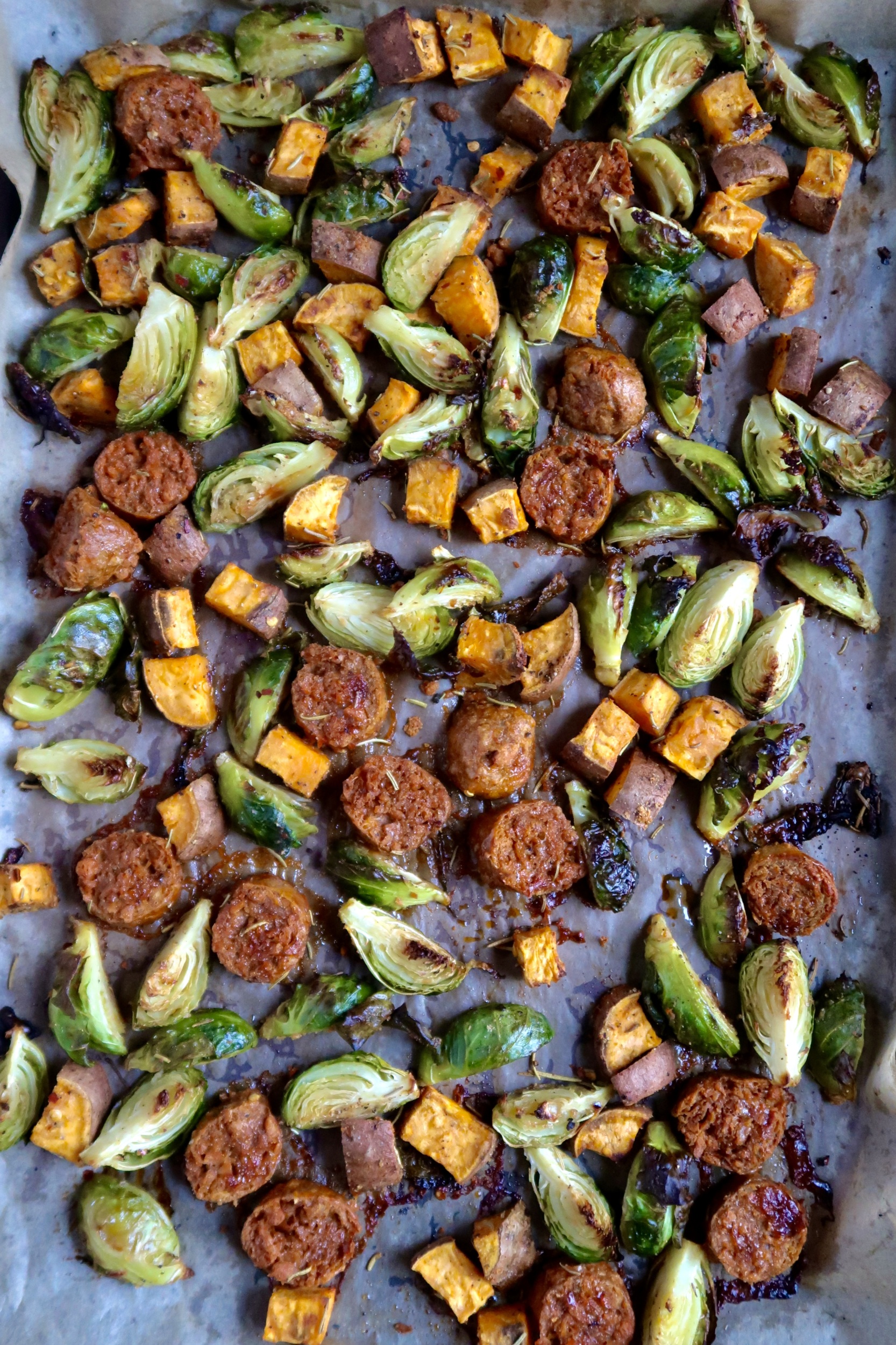 Sheet pan with roasted diced brussel sprouts, sausage and sweet potato and spices