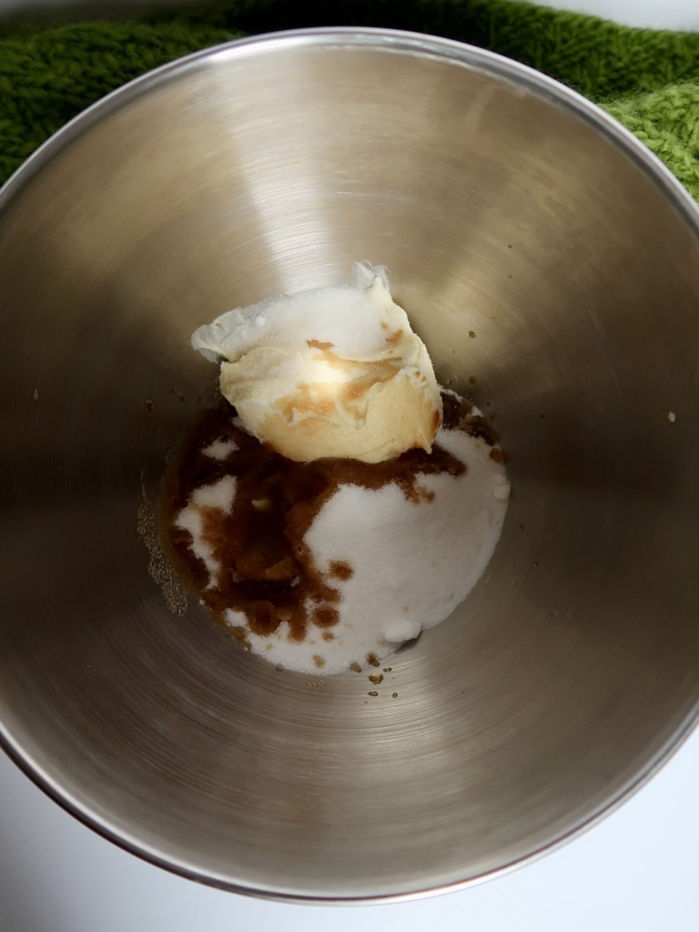 Silver mixing bowl with butter, sugar, vanilla inside.
