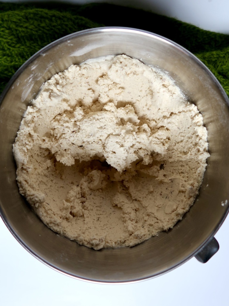 Silver bowl with mixed cookie dough inside.