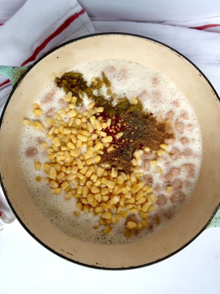 Large pot with soy curls and a creamy base with diced green chilis and corn.