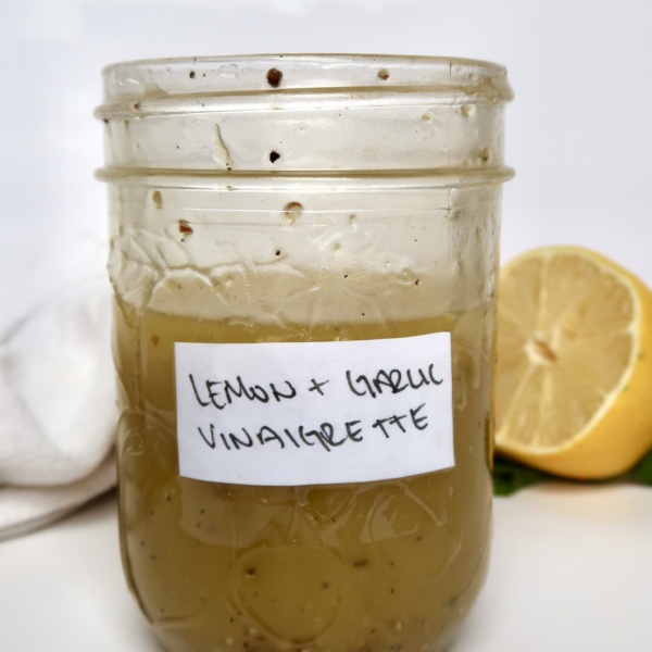 Mason jar with lemon and garlic as a label with vinaigrette inside.