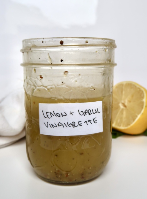 Mason jar with lemon and garlic as a label with vinaigrette inside.