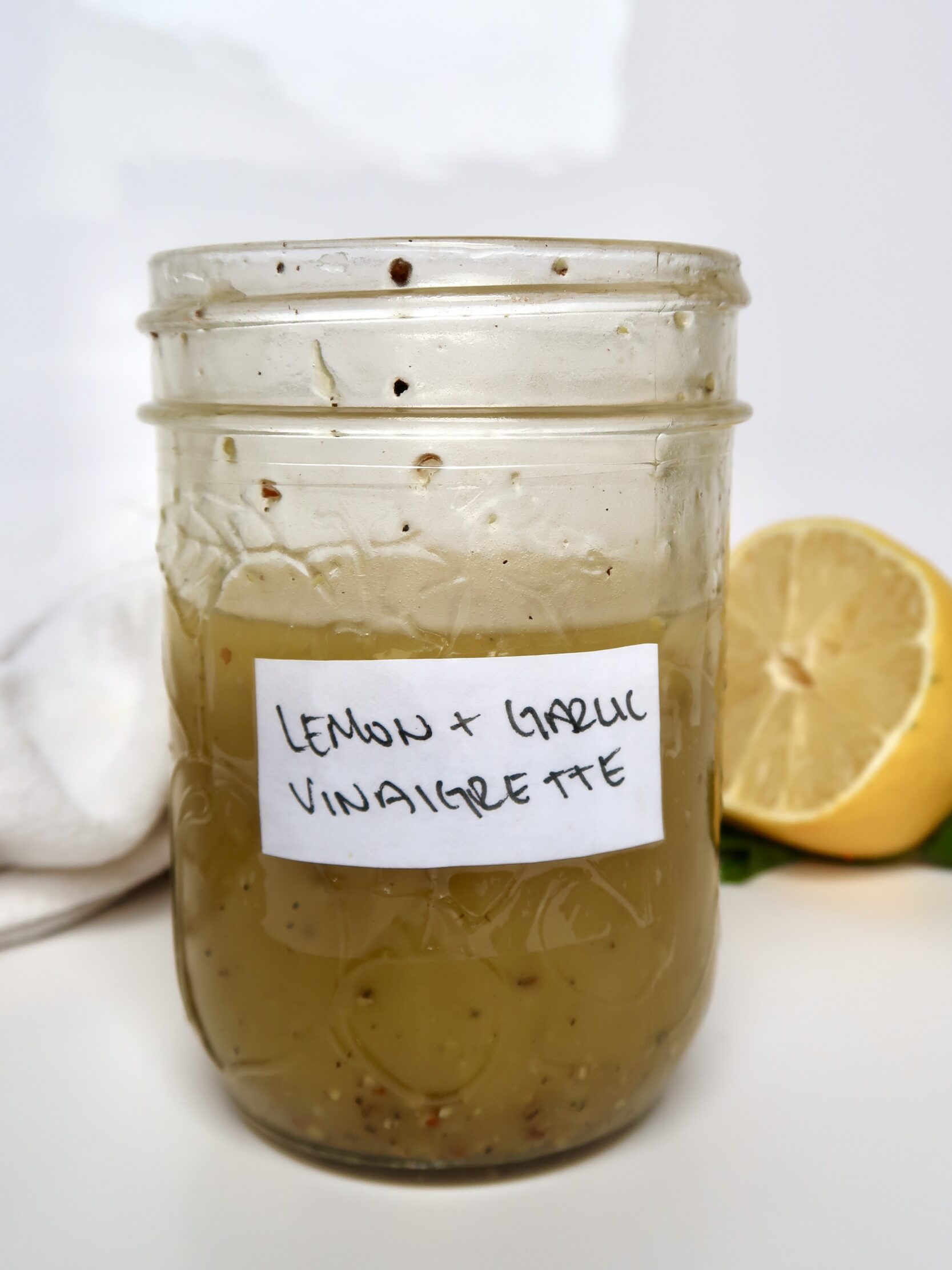 Mason jar with lemon and garlic as a label with vinaigrette inside.