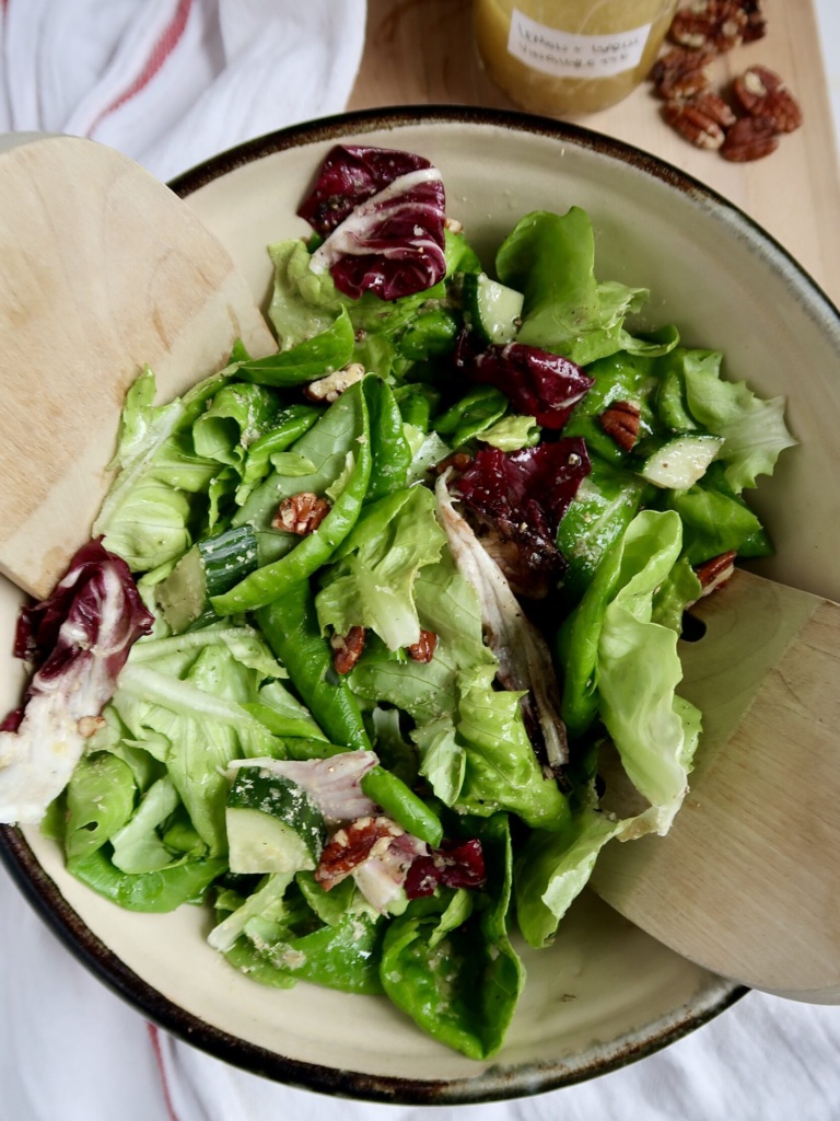 Bowl with tongs and greens inside.