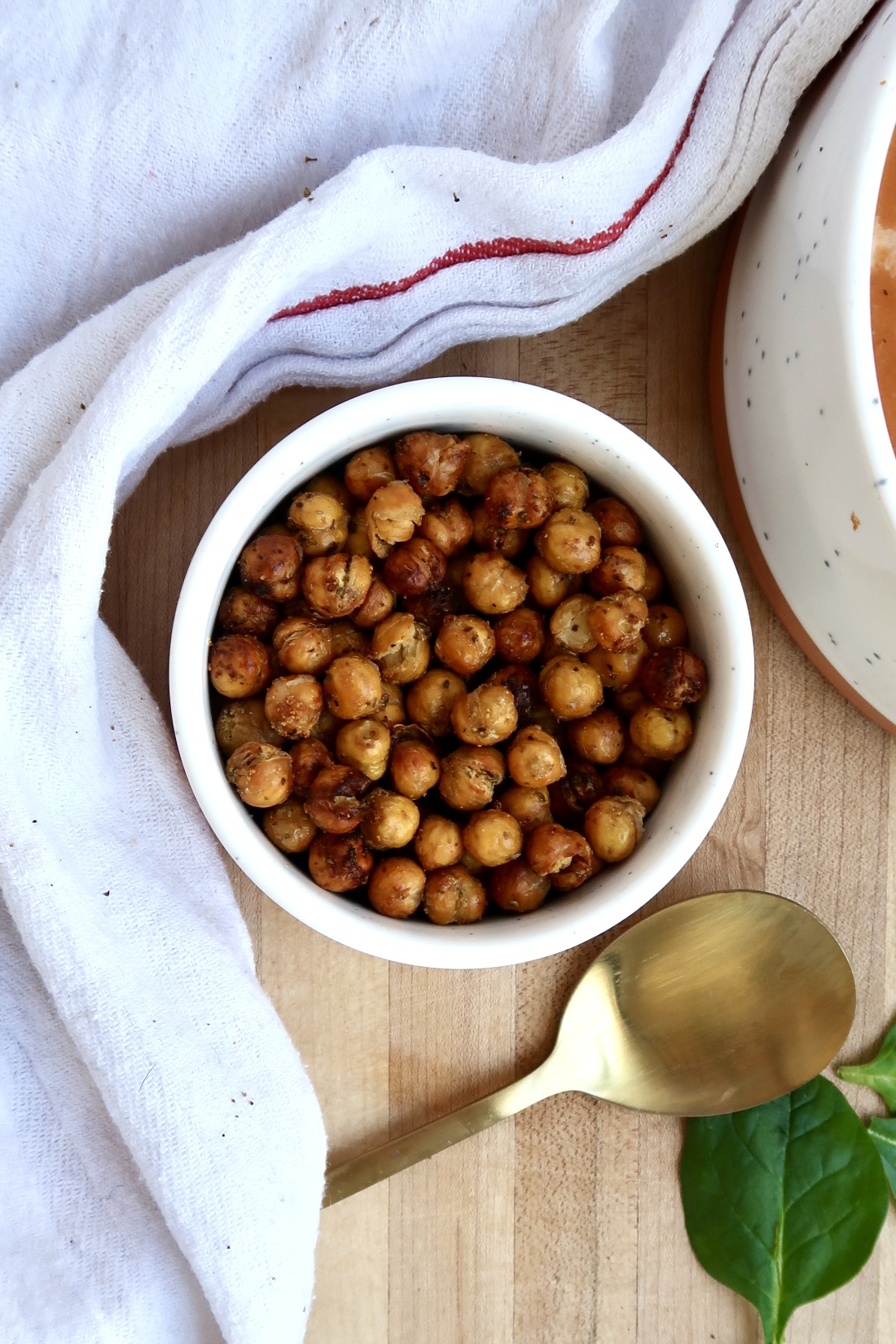 Small bowl with crispy chickpeas and a spoon to the side.