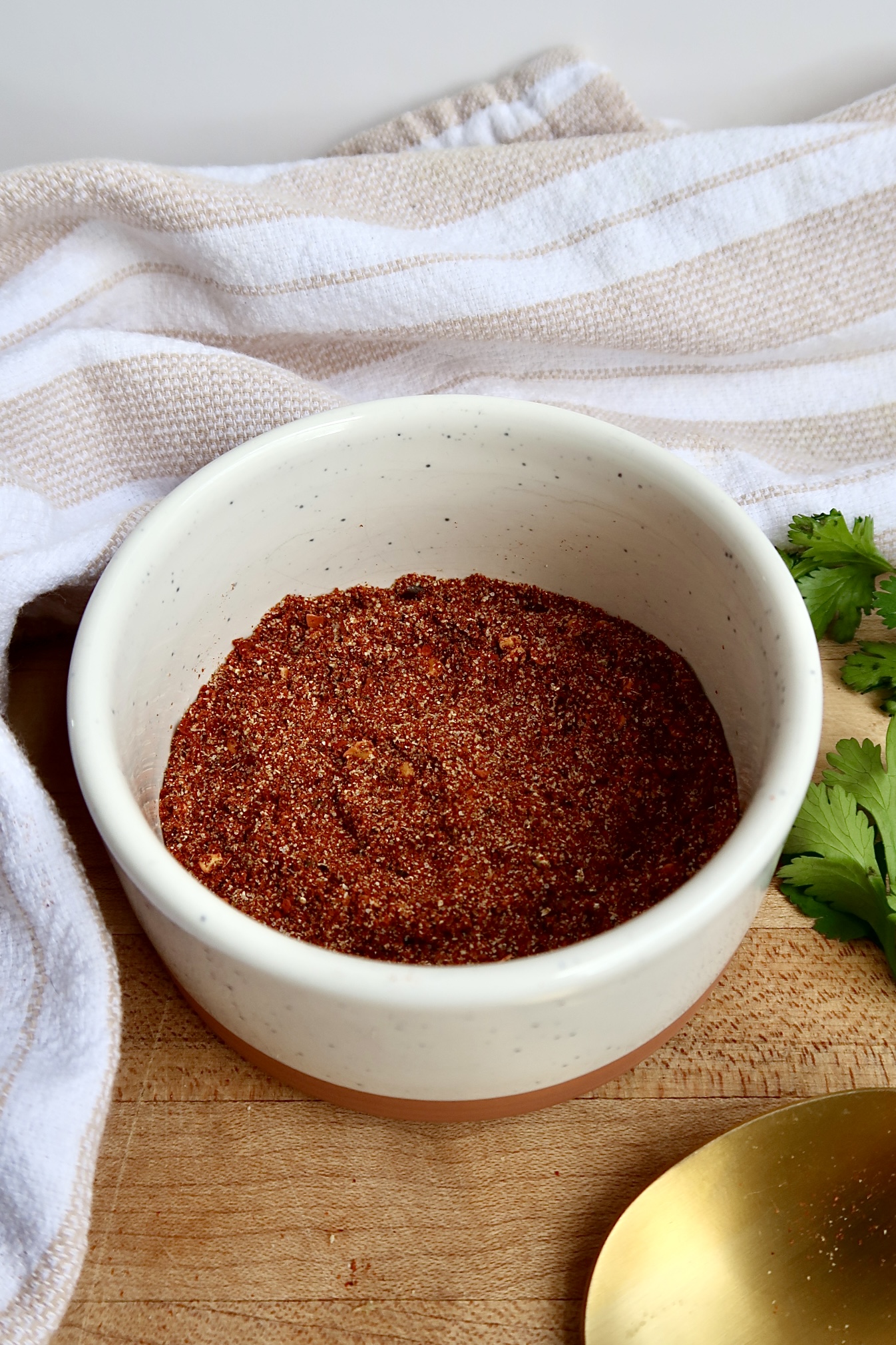 Side view of white ramekin with chili spices in it.