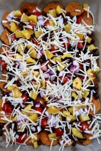 Sweet potato nachos with veggies and beans and cheese on top.