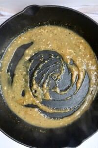 Slightly thickened lemon pepper sauce in a pan.