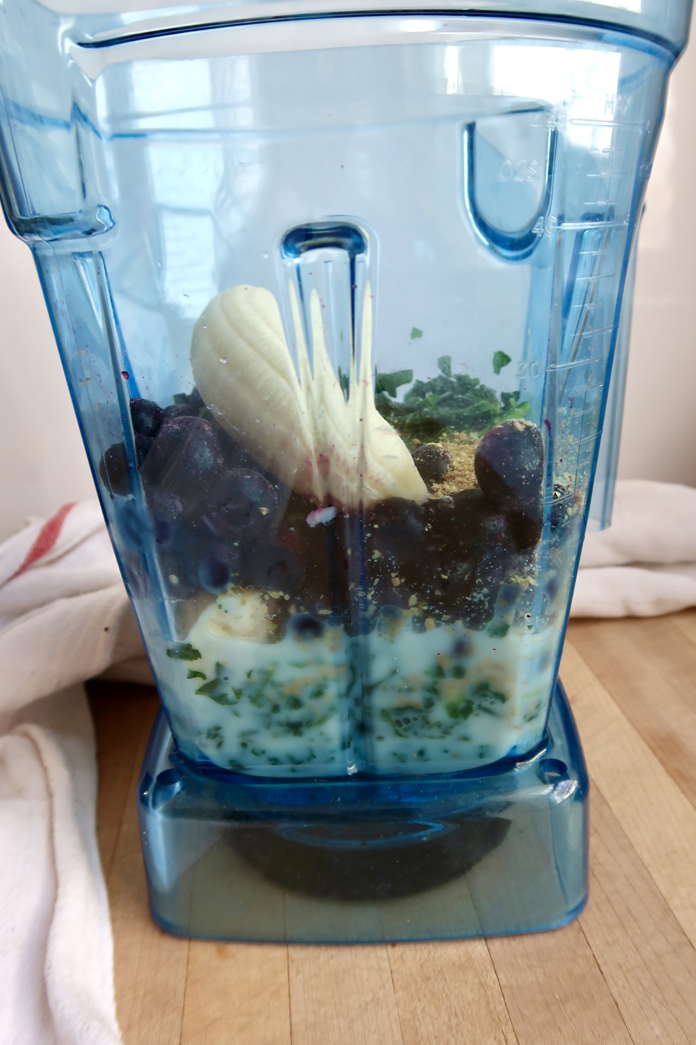 Ingredients for blueberry kale smoothie in a blender.