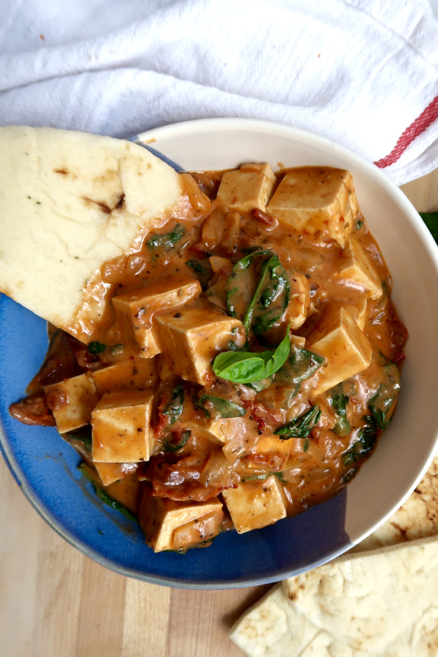 Marry me tofu in a bowl with naan bread on the side.