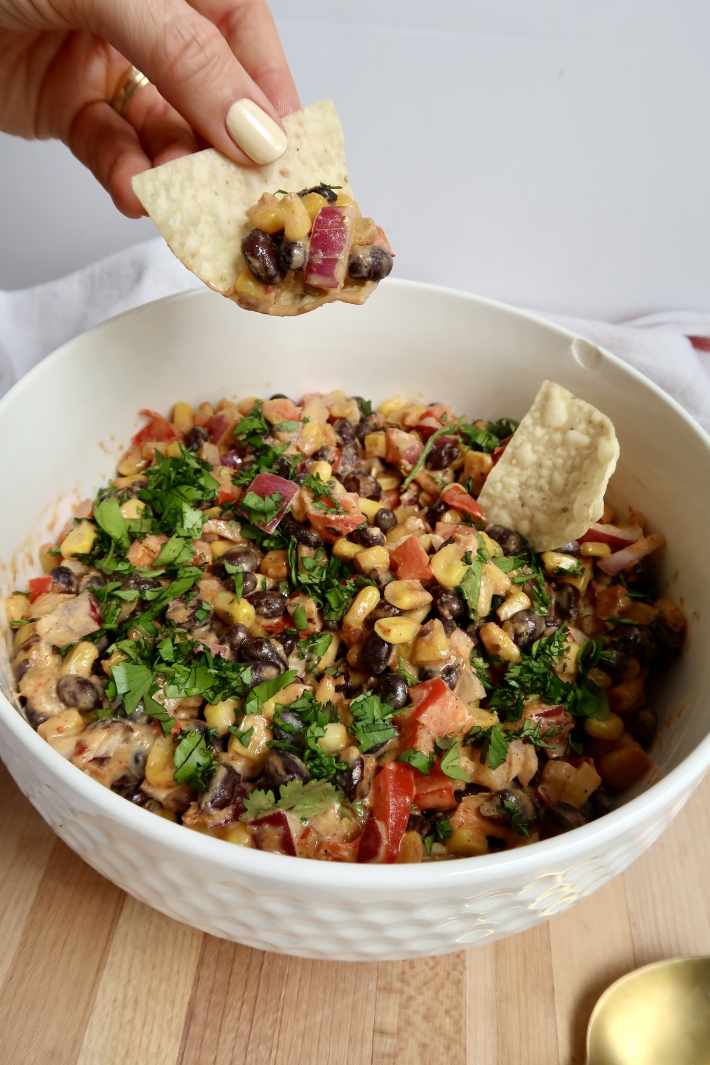 Corn chip being dipped in black bean and corn salad